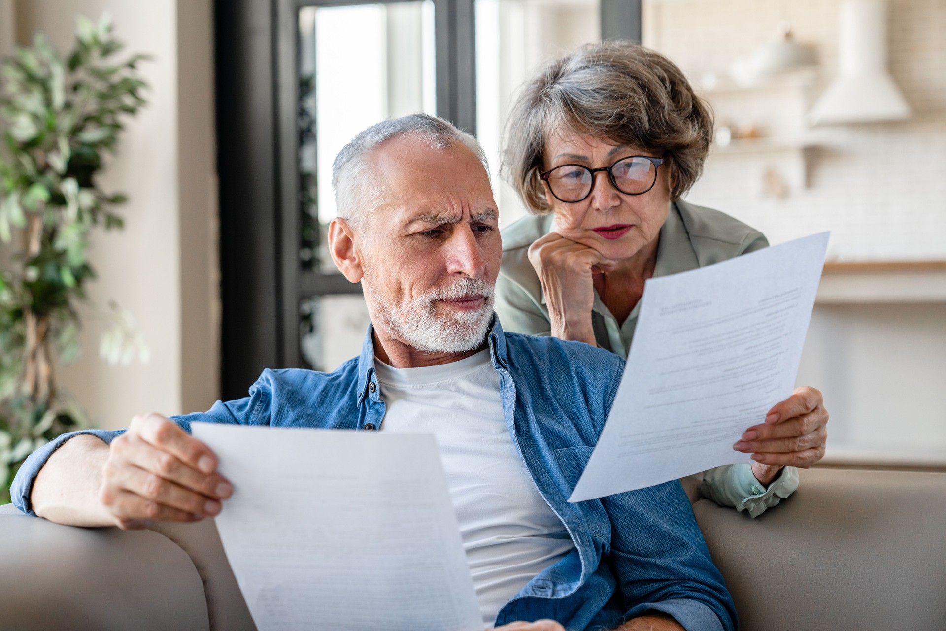 Senior grandparents reading documents, having issue problem debt with money loss