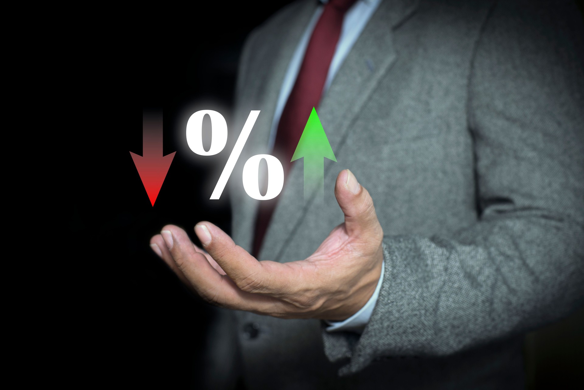 Businessman hand showing percentage sign with arrow up and down. Interest rate financial and mortgage rates, finance, economy, mortgage, loan, investment, stock and dividends.